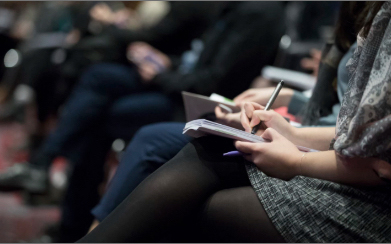 imagen de alumnos tomando notas en una conferencia